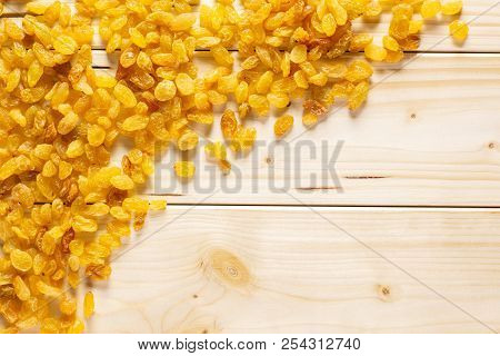 Lot Of Whole Dry Golden Raisins Sultana Variety Left Upper Corner Flatlay On Natural Wood
