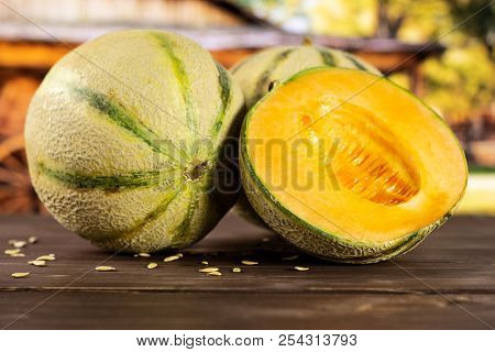 Group Of One Whole One Half Of Fresh Melon Cantaloupe Variety With Seeds Around With Cart In Backgro