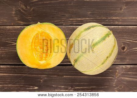 Group Of One Whole One Half Of Fresh Melon Cantaloupe Variety Flatlay On Brown Wood