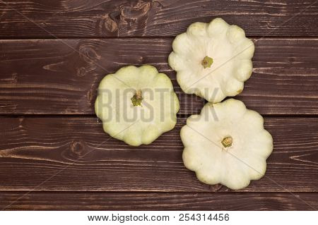 Group Of Three Whole Summer White Pattypan Squash Flatlay On Brown Wood