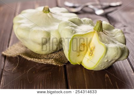 Group Of Two Whole Summer White Pattypan Squash One Sliced On Linen Cloth On Brown Wood