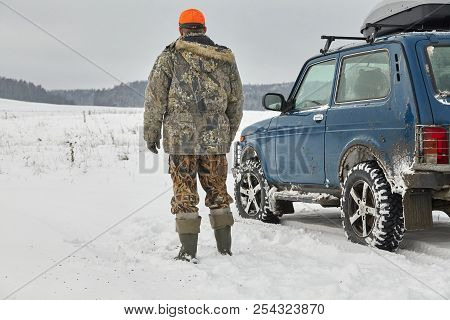 Hunter In Camouflage With With Hunting Car In Winter Forest
