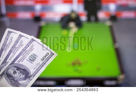 Money Dollars On The Background Of A Tv On Which Show A Game Of Snooker, Sports Betting, Dollars