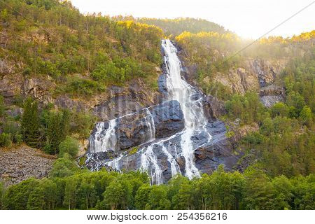 Beautiful Waterfall In Mountains At Sunset Lights In Norway