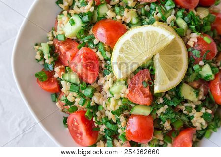 Tabbouleh (tabouli) Salad On A Dish On Light Background. Healthy Vegetarian Food. Lebanese Cuisine. 