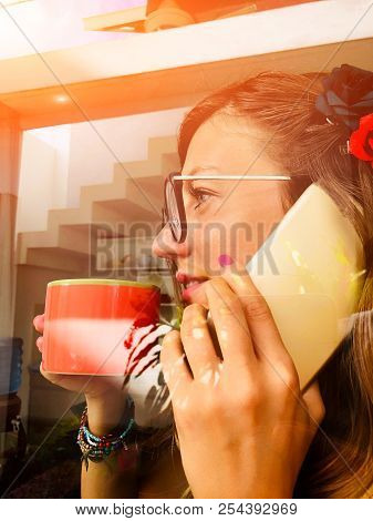 Woman Talking On The Cellphone And Drinking Coffee Iside The Apartment - Window, Glass, Reflection.
