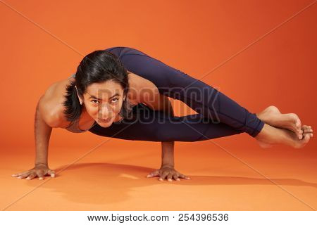 Eight-angle Yoga Pose Woman Show On Orange Color Studio Background