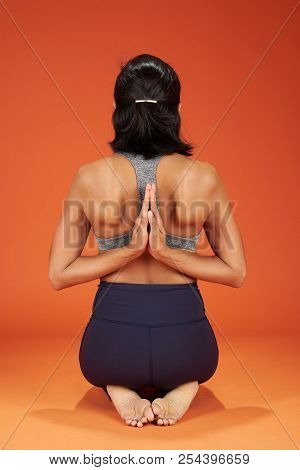 Reverse Prayer Yoga Pose Woman Show On Orange Studio Background