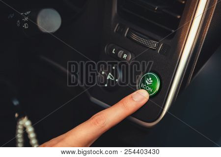 Close Up Portrait Of Woman Finger Is Pressing Switch On/off Of Eco Mode In The Car., Eco Concept