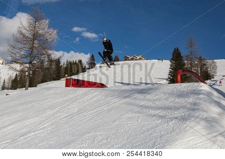 Skier In Action: Ski Jumping In The Mountain Snowpark.