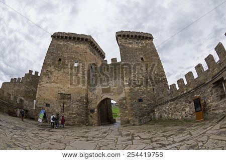 Sudak, Crimea - April 2, 2018: Genoese Fortress In Sudak, Crimea. A Small Group Of Tourists On The S