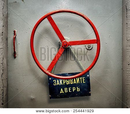 Armored Bunker Door With Hanging Shabby Signboard With Russian Close The Door Warning