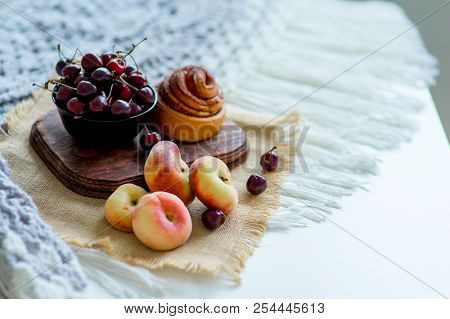 Homemade Cinnamon Buns In Glaze On A Dark Plate With Berries