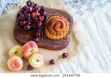 Homemade Cinnamon Buns In Glaze On A Dark Plate With Berries