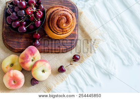 Homemade Cinnamon Buns In Glaze On A Dark Plate With Berries