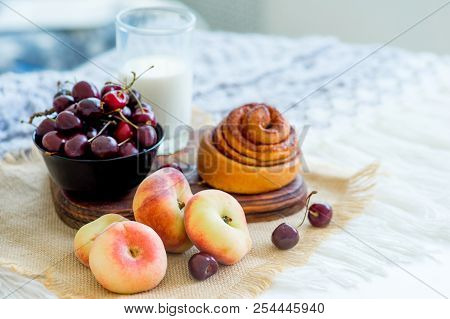 Homemade Cinnamon Buns In Glaze On A Dark Plate With Berries