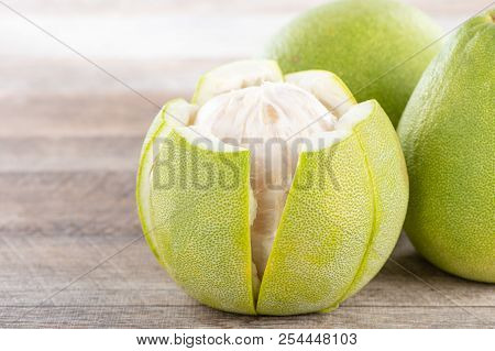 Fresh And Peeled Pomelo(shaddock), Grapefruit With Slices On Wooden Table Background