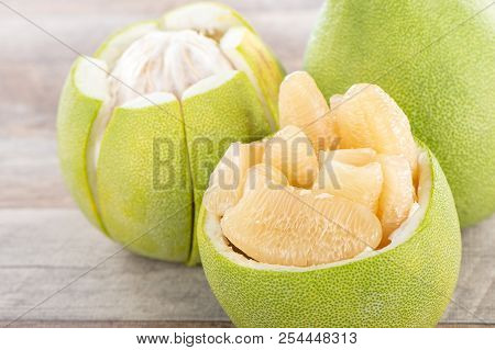 Fresh And Peeled Pomelo(shaddock), Grapefruit With Slices On Wooden Table Background