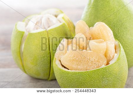 Fresh And Peeled Pomelo(shaddock), Grapefruit With Slices On Wooden Table Background
