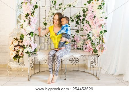Happy Family. Mother Throws Up Mixed Race Baby Playing At Home