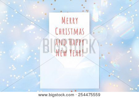 Christmas Card In Blue Envelope On Blue Background Decorated With Confetti. Holiday And Invitation M