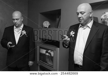 Lutsk, Volyn / Ukraine - November 14 2009: Groom And Guest Using Mobile Smart Phones