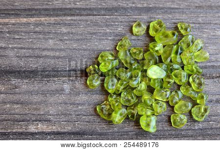 Olivine Gemstone Also Called Peridot On Old Wooden Background.selective Focus.
