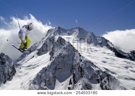 Freestyle Ski Jumper With Crossed Skis In High Snowy Mountains At Sunny Winter Day