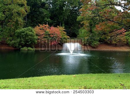 Water Fountain in the middle of a pond on a Fall day