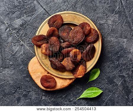 Brown Sun Dried Apricots On Black Table. Top View.