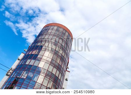 Modern Skyscraper With A Unique Round Shape, Cloudy Sky Background, Copy Space