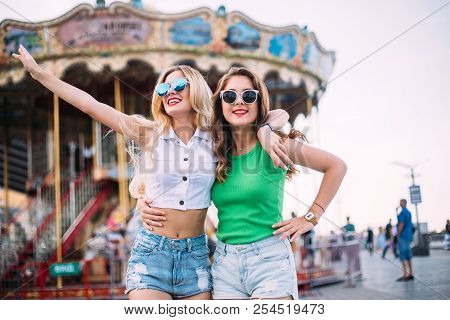 Happy Brightful Positive Moments Of Two Stylish Girls Hugging On Street In City. Closeup Portrait Fu