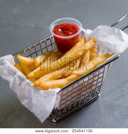 French Fries In A Steel Basket On A Table