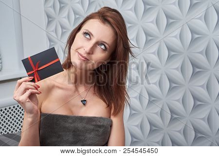 The Client Of The Cosmetology Clinic Shows A Gift Card