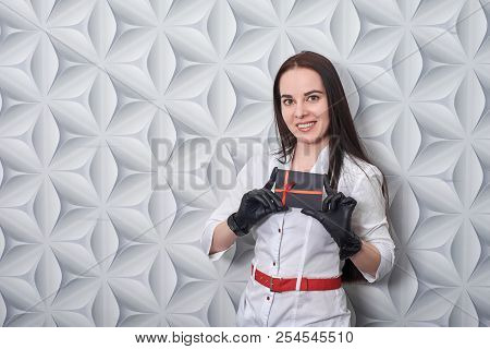 Beautician In A Medical Gown Shows A Gift Card