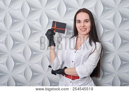 Doctor In A Medical Gown Shows A Gift Card