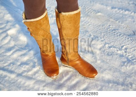 Leg Woman Winter Brown Fur Boots Walking On The Snow In A Winter Park. Closeup Outsole Of Warm Boot.