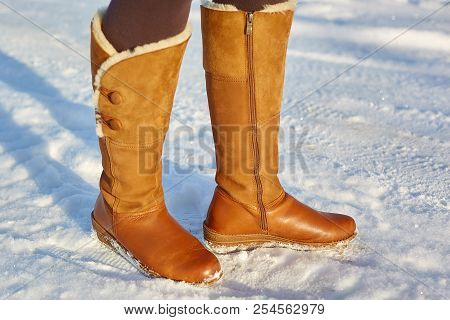 Leg Woman Winter Brown Fur Boots Walking On The Snow In A Winter Park. Closeup Outsole Of Warm Boot.