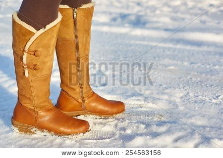 Leg Woman Winter Brown Fur Boots Walking On The Snow In A Winter Park. Closeup Outsole Of Warm Boot.