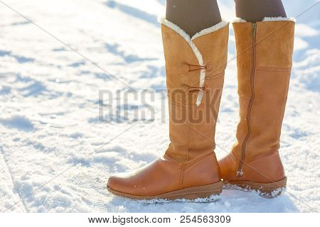 Leg Woman Winter Brown Fur Boots Walking On The Snow In A Winter Park. Closeup Outsole Of Warm Boot.