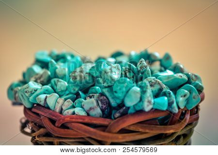 Pile Stones Of Raw Turquoise In Small Wooden Nest On A Brown Background. Blue And Green Color Stones