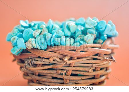Pile Stones Of Raw Turquoise In Small Wooden Nest On A Brown Background. Blue And Green Color Stones
