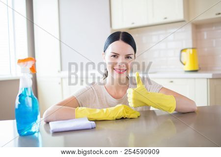 Nice And Hardworking Girl Poses On Camera. She Looks Straight. Girl Holds Her Big Thumb Up. Blue Spr