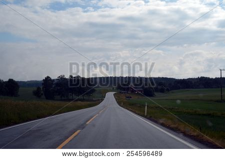 A typical Norwegian road in the countryside. June 16. 2018. Ostfold Region, Norway