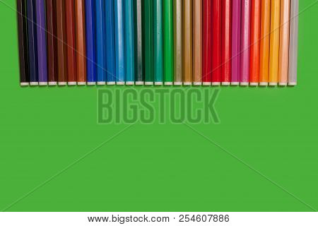 Line Of Various New Bright Plastic Multicolored Felt Pens Lying On A Green Surface. Concept Of Creat