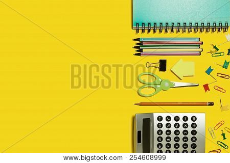 Multiple School And Office Suplies And Gadgets Lying Diagonally On A Yellow Background. Free Space F