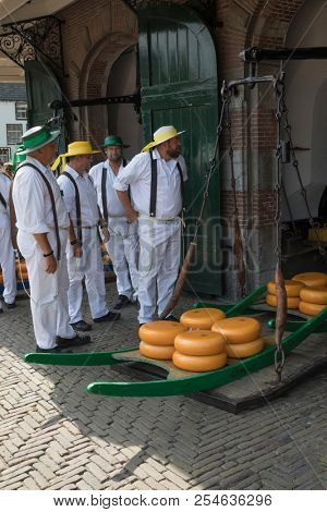 Alkmaar, Netherlands - July 20, 2018: Cheese carriers waiting for the cheeses to be weighted on the scale in the Waag building before being sold on the market