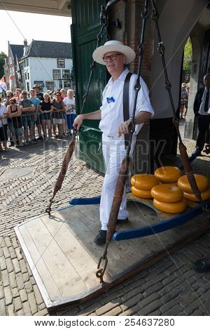 Alkmaar, Netherlands - July 20, 2018: Cheese carriers waiting for the cheeses to be weighted on the scale in the Waag building before being sold on the market