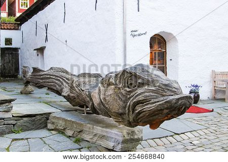 Bergen Norway - 2016-10-07 : Enormous Wood Carving Of A Dried Codfish In The Old Wharf Area Of Brygg