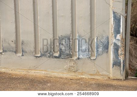 A Concrete Wall On A Bridge  That Was Been Damaged By An Odject Passing By Or Crashing Into It